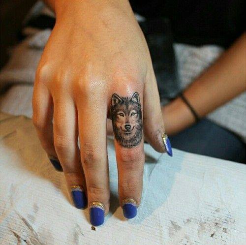 Девушка с татуировкой волка на пальце
