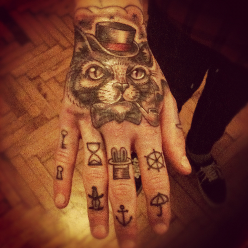 Татуировка кота в шляпе на руке