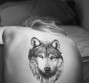 Татуировка волка на спине у девушки