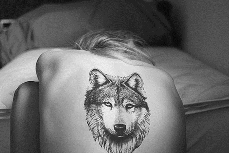 Татуировка волка на спине у девушки