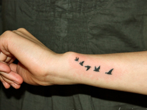 Летящие черные птицы на руке