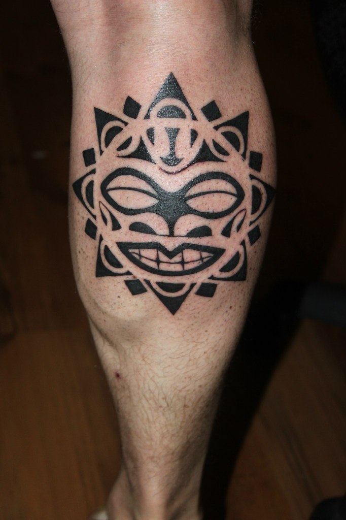 Черная полинезийская тату у мужчины на ноге