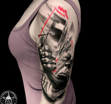 Женщина с татуировкой на плече в стиле треш-полька