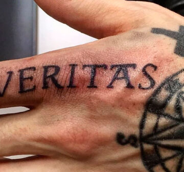 Надпись Veritas и компас на руке