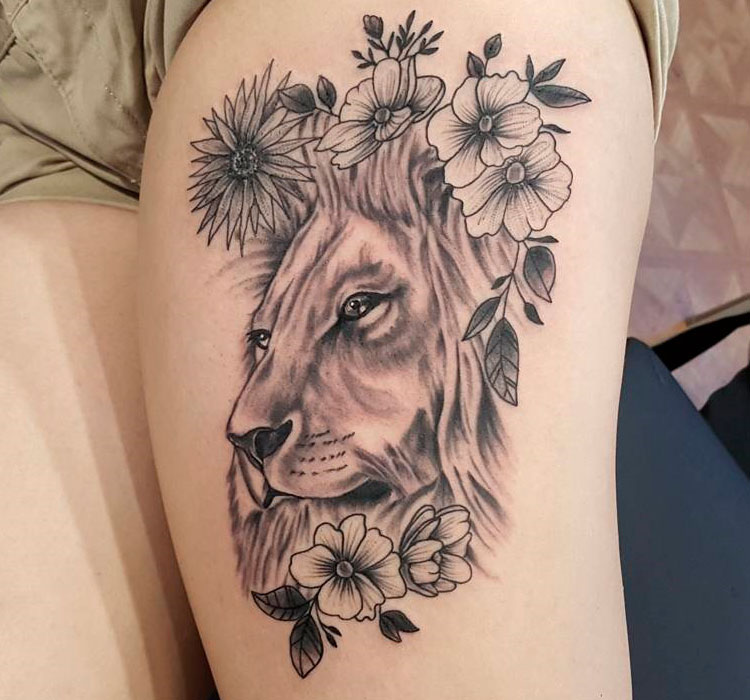Голова льва с цветами на бедре у девушки
