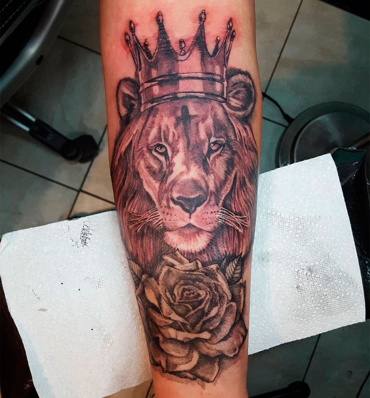 Лев с короной на предплечье у мужчины