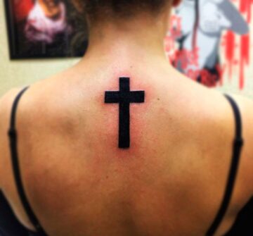 Черный крест на спине у девушки