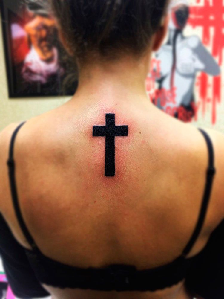 Черный крест на спине у девушки