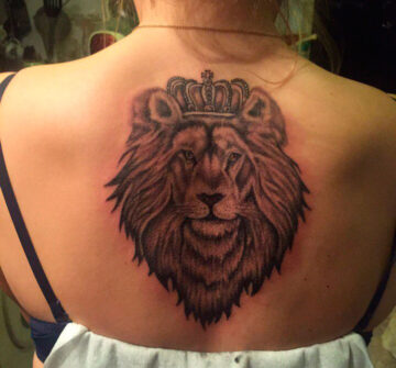 Лев в короне на спине у девушки