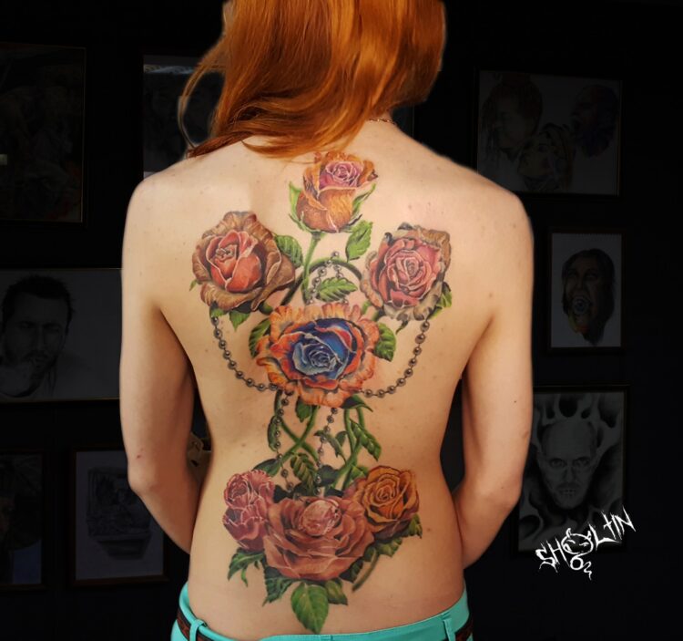 Большая цветочная татуировка на спине у девушки
