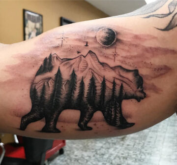 Силуэт медведя с деревьями и горами, мужская тату на бицепсе