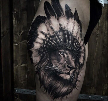 Лев с индейскими перьями, женская тату на бедре
