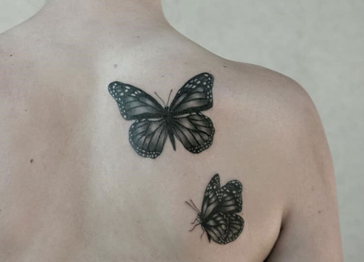 Две черные бабочки, тату на спине у девушки