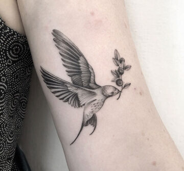 Птица с веточкой черники, тату на руке у девушки