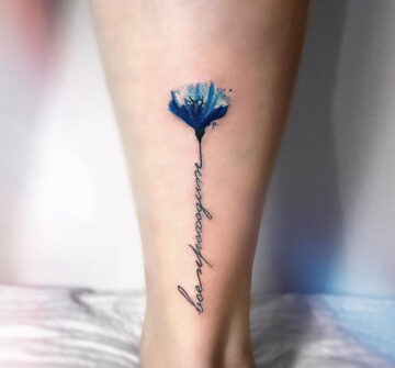 Синий цветок с надписью, тату на задней части голени у девушки