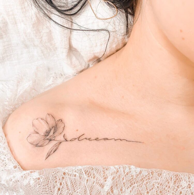 Тату лайнворк, надписи на английском, цветы  на ключице у девушки