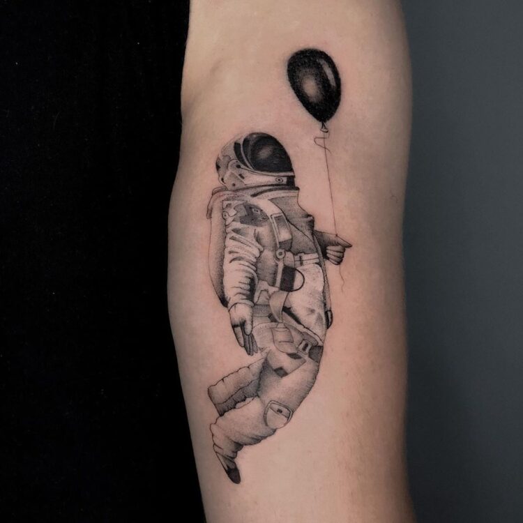 Космонавт с шариком, тату на бицепсе у парня