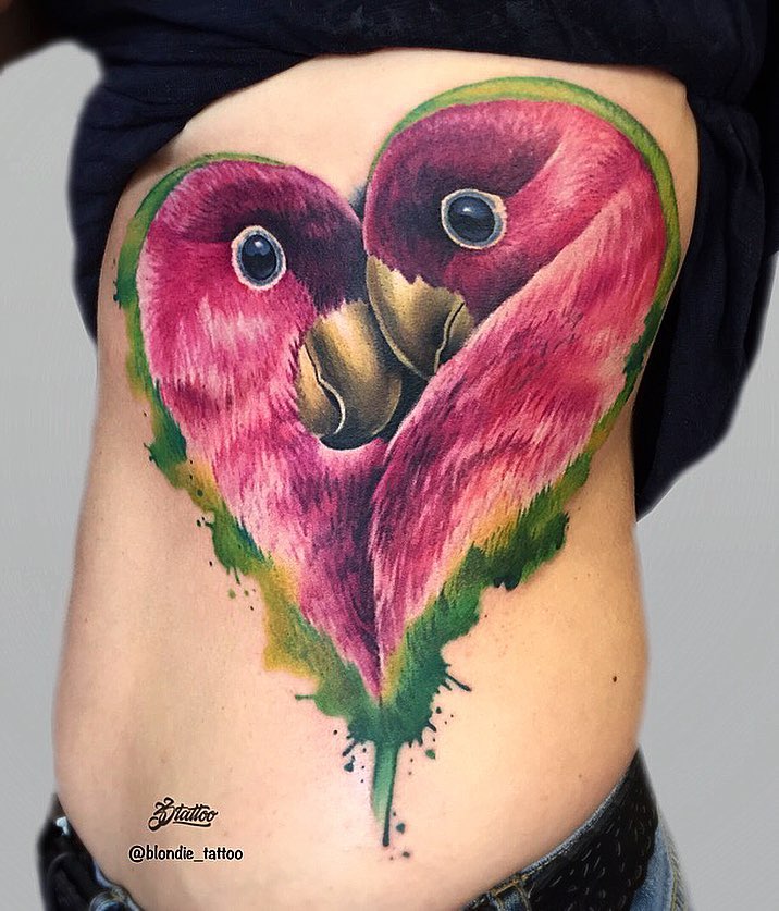 Два попугая в форме сердца, тату на боку у девушки