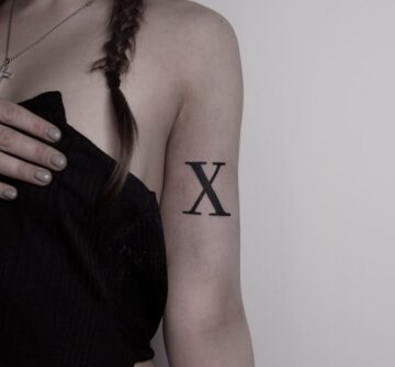 "X", тату надпись на плече у девушки