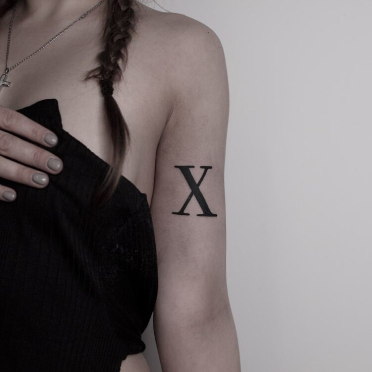 "X", тату надпись на плече у девушки