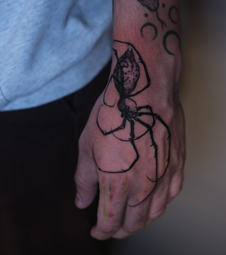 Тату паук в стиле блэкворк на кисти руки у парня